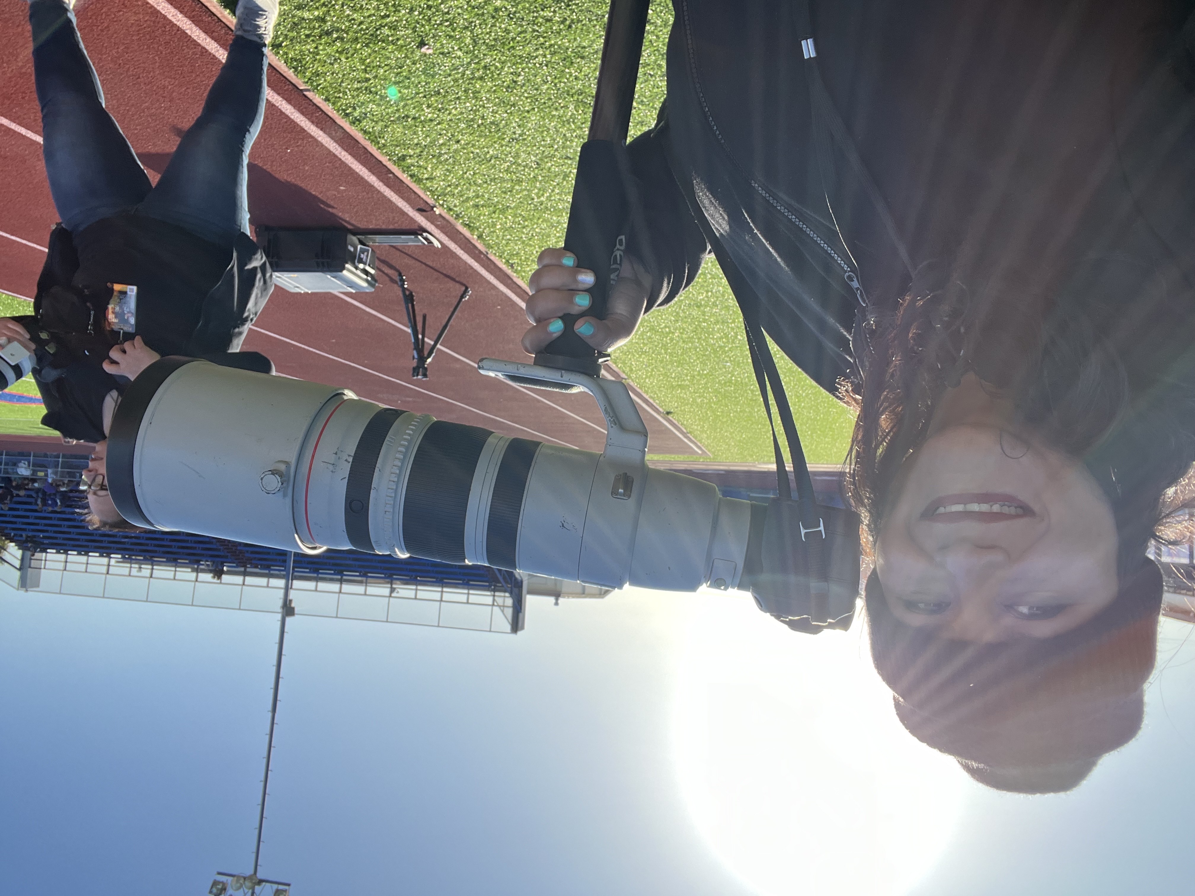 picture of owner in a black sweater hold a sports camera live on football field